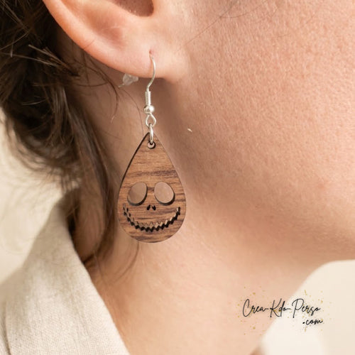 Boucle d'oreille en bois motif visage de squelette mesurant 3 cm de haut par 1,9 cm de large