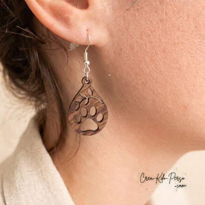 Boucle d'oreille en contreplaqué de bois découpée motif patte d'animal et branche portée sur oreille