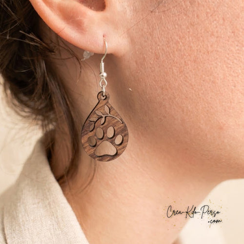 Boucle d'oreille en contreplaqué de bois découpée motif patte d'animal et branche portée sur oreille