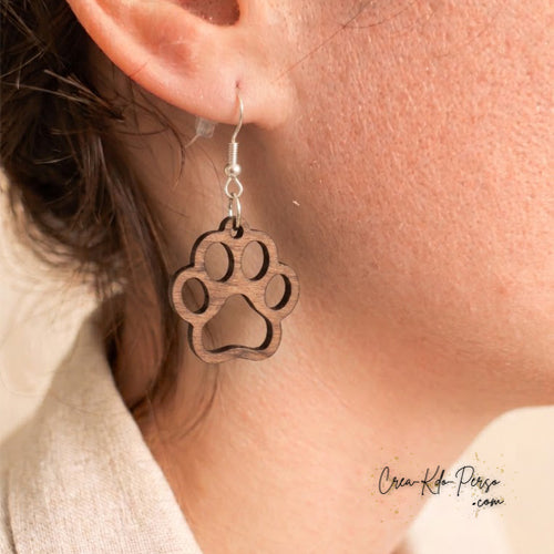 Boucle d'oreille en contreplaqué de bois découpée motif patte d'animal portée sur oreille